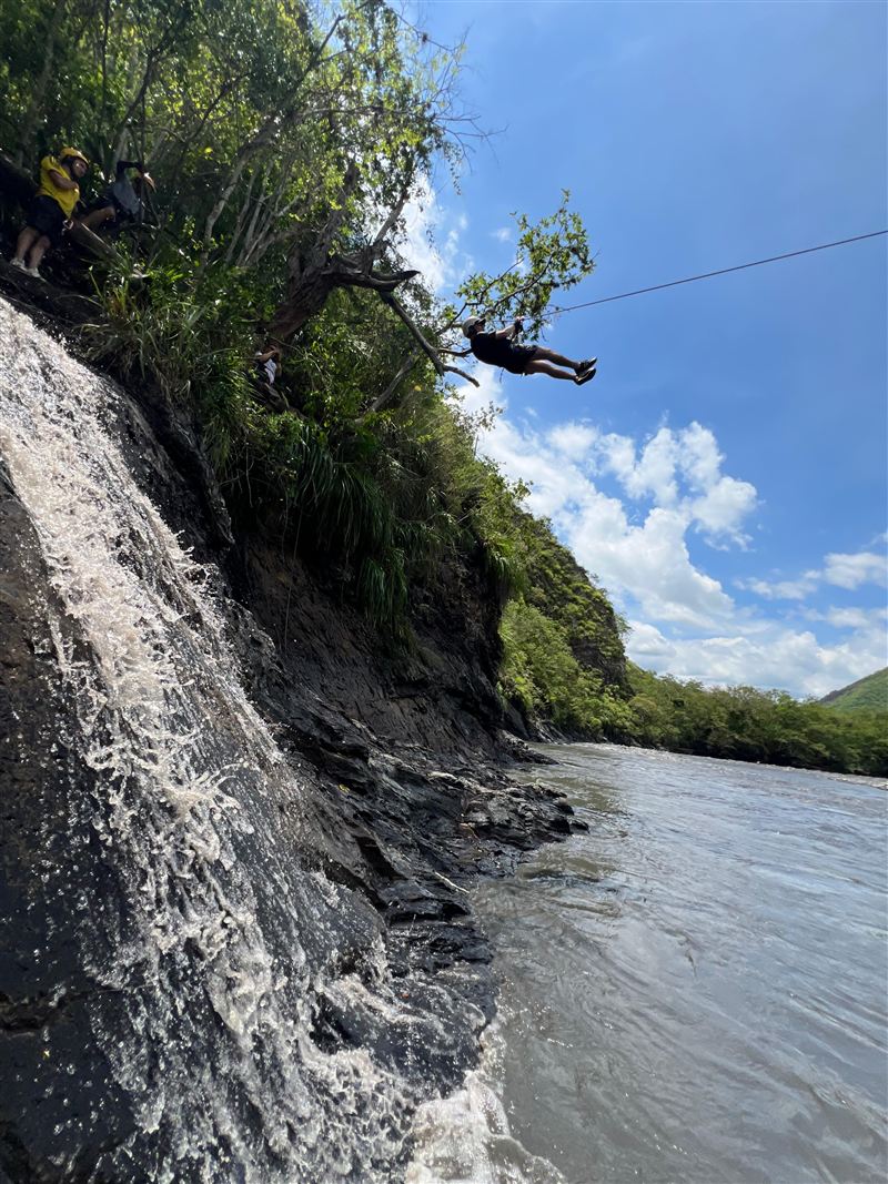 Aventurero en tirolina con arnés sobre el valle en canopy extremo de Útica